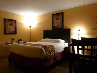 a hotel room with a large bed and a table at Motel Becancour in Bécancour