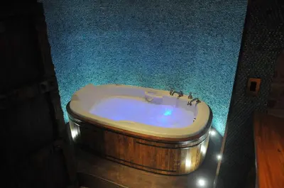 a bathroom with a bath tub with a toilet in it at Manoir Ramezay in Marieville