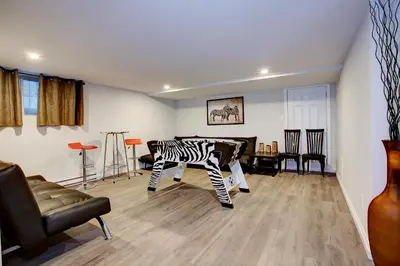 a living room with a zebra table and chairs at Modern Townhouse with Rooftop Deck in Montréal