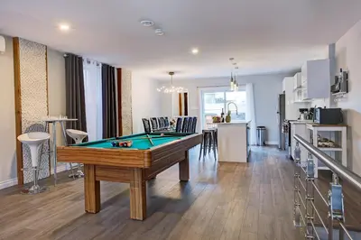 a living room with a pool table and a kitchen at Modern Townhouse with Rooftop Deck in Montréal