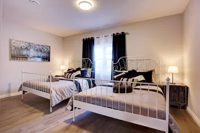 a bedroom with two beds and a window at Modern Townhouse with Rooftop Deck in Montréal