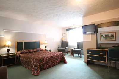 a hotel room with a bed and a flat screen tv at Motel Marie-Dan in Sainte-Eulalie
