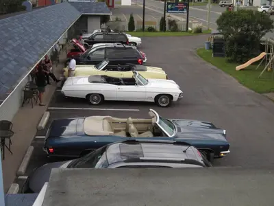 a group of cars parked in a parking lot at Motel Montgolfière JP in Saint-Jean-sur-Richelieu