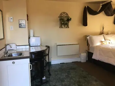 a bathroom with a sink and a bed in a room at Motel Montgolfière JP in Saint-Jean-sur-Richelieu