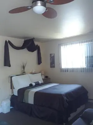 a bedroom with a bed with a ceiling fan and a window at Motel Montgolfière JP in Saint-Jean-sur-Richelieu