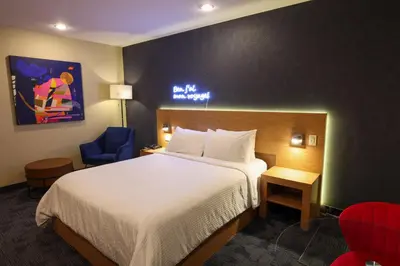 a hotel room with a bed and a chair at Le Fabreville Motel & Suites in Laval