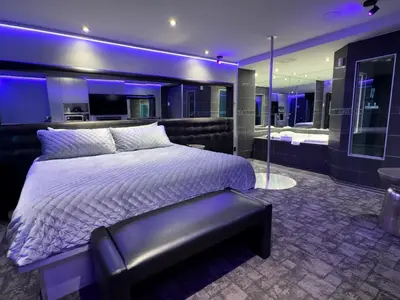 a bedroom with a king sized bed and a bench at Le Fabreville Motel & Suites in Laval