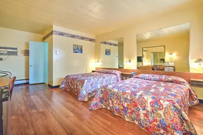 a hotel room with two beds and a mirror at Motel R-100 in Longueuil