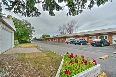 a street with cars parked in a parking lot at Motel R-100 in Longueuil