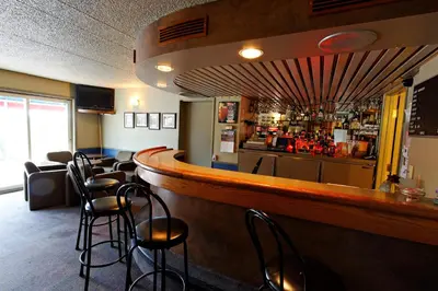 a bar with a row of stools in a restaurant at Hotel Transit in Mont-Saint-Hilaire