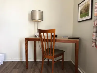a wooden desk with a chair and a lamp at Hotel Transit in Mont-Saint-Hilaire