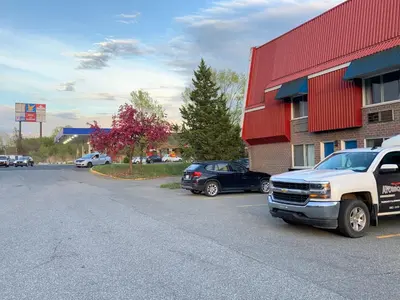 a truck parked in a parking lot next to a building at Hotel Transit in Mont-Saint-Hilaire