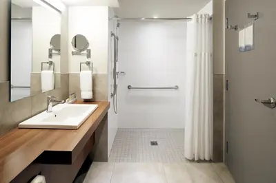 a bathroom with a sink and a shower at Hôtel Rive Gauche in Beloeil Village