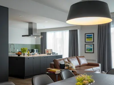 a kitchen and living room with a couch and a table at Hôtel Rive Gauche in Beloeil Village