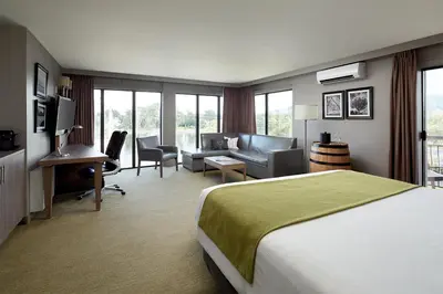 a hotel room with a bed and a living room at Hôtel Rive Gauche in Beloeil Village