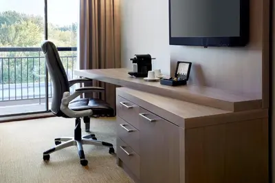 a desk with a chair in a room with a window at Hôtel Rive Gauche in Beloeil Village