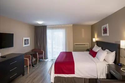 a hotel room with a large bed and a television at Hotel Bromont in Bromont
