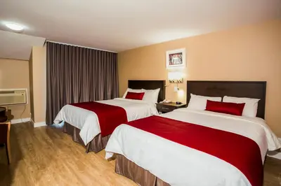 a hotel room with two beds with red pillows at Hotel Bromont in Bromont