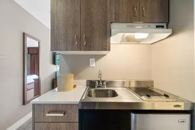 a small kitchen with a sink and a stove at Hotel Bromont in Bromont