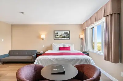 a hotel room with a bed and a table with a laptop on it at Hotel Bromont in Bromont