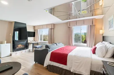 a hotel room with a bed and a fireplace at Hotel Bromont in Bromont