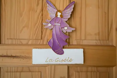 a wooden door with a purple angel sign on it at Le Gite A Margot in Bromont