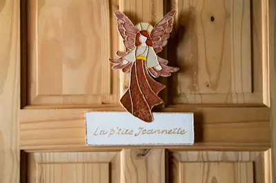 a wooden angel hanging on a door with a sign at Le Gite A Margot in Bromont