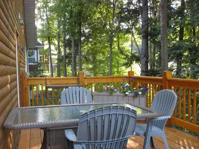 a table and chairs on a wooden deck at Le Gite A Margot in Bromont