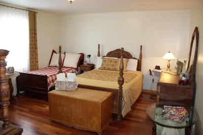 a bedroom with two beds and a table at Le Gite A Margot in Bromont