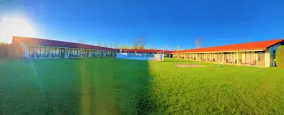 a large building with a grass field next to it at Hotel Motel Bonsoir in Granby