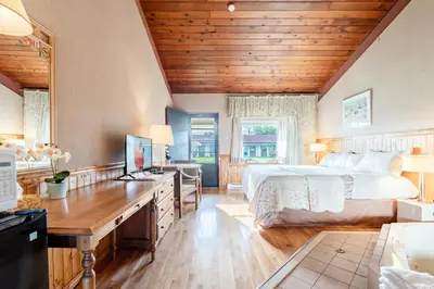 a bedroom with a bed and a desk with a computer at Hotel Motel Bonsoir in Granby