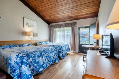 a hotel room with two beds and a table at Hotel Motel Bonsoir in Granby