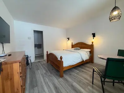 a bedroom with a bed and a desk and a television at Hotel Motel La Marquise in Sherbrooke