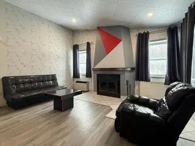 a living room with a couch and a fireplace at Hotel Motel La Marquise in Sherbrooke
