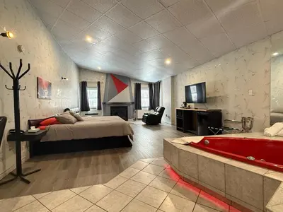 a bedroom with a bed and a tub in a room at Hotel Motel La Marquise in Sherbrooke