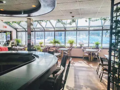 a restaurant with tables and chairs and a pool table at Hotel Motel La Marquise in Sherbrooke