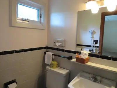 a bathroom with a toilet and a sink and a mirror at Motel & Hotel La Paysanne in Sherbrooke