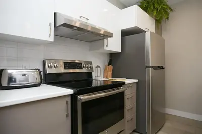 a kitchen with a stove and a refrigerator at Montreal Contemporary Apartment Free Parking in Montréal