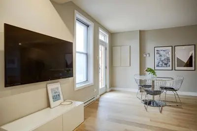 a living room with a table and a large tv at Montreal Contemporary Apartment Free Parking in Montréal