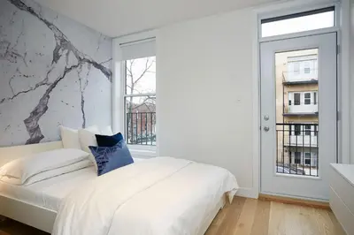 a bedroom with a white bed and a window at Montreal Contemporary Apartment Free Parking in Montréal