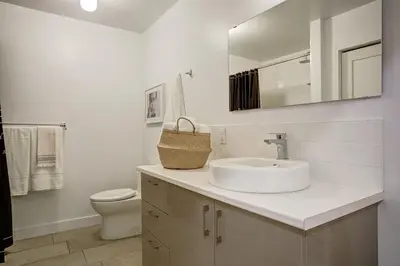 a white bathroom with a sink and a toilet at Montreal Contemporary Apartment Free Parking in Montréal