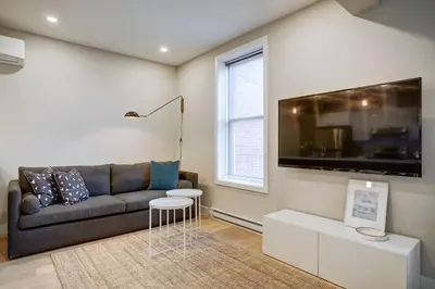 a living room with a couch and a tv at Montreal Contemporary Apartment Free Parking in Montréal