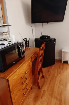 a microwave sitting on top of a wooden table with a wooden counter at Motel Bonsoir in Joliette