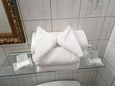 a pile of towels on a glass table in a bathroom at Motel Bonsoir in Joliette