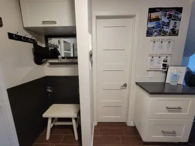 a small kitchen with a white door and a stool at Condo de L'Oberge in Magog-Orford