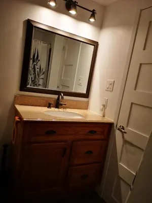 a bathroom with a sink and a mirror at Condo de L'Oberge in Magog-Orford