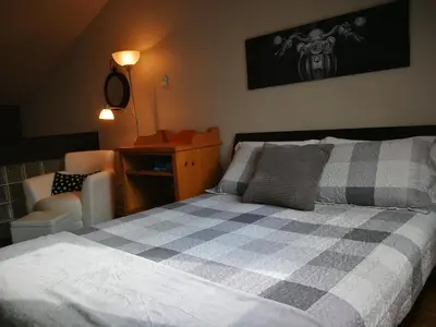 a bedroom with a checkered bed and a chair at Condo de L'Oberge in Magog-Orford