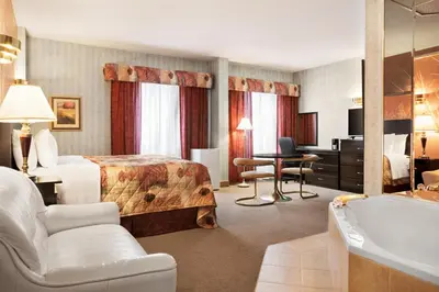a hotel room with a bed and a bath tub at Days Inn by Wyndham Ste. Helene-de-Bagot in Sainte-Hélène-de-Bagot