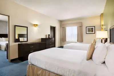 a hotel room with two beds and a mirror at Days Inn by Wyndham Ste. Helene-de-Bagot in Sainte-Hélène-de-Bagot
