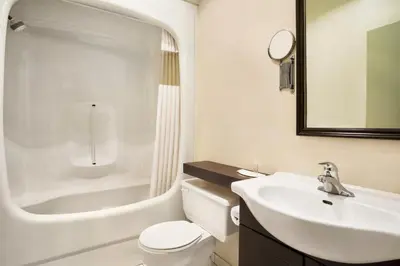 a bathroom with a white toilet and a sink at Days Inn by Wyndham Ste. Helene-de-Bagot in Sainte-Hélène-de-Bagot